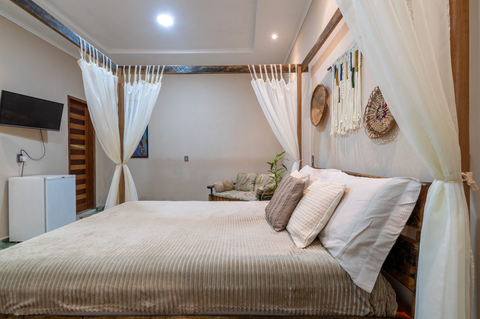 Cama com dossel, TV e frigobar — Suíte Guarani